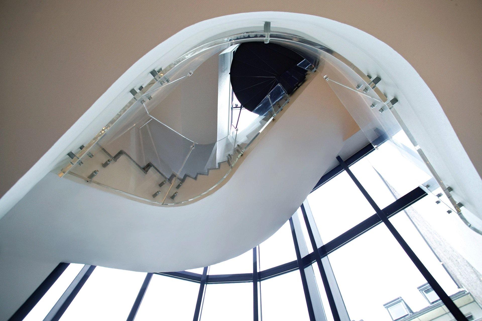 Geschwungenes Treppenhaus mit Glasfassade